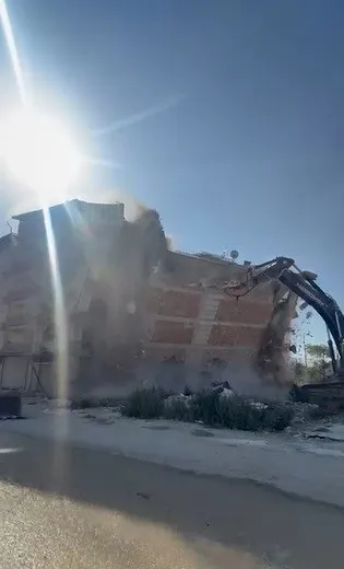 İş makinası, üzerine doğru yıkılan 6 katlı binanın altında kalmaktan saniyelerle kurtuldu
